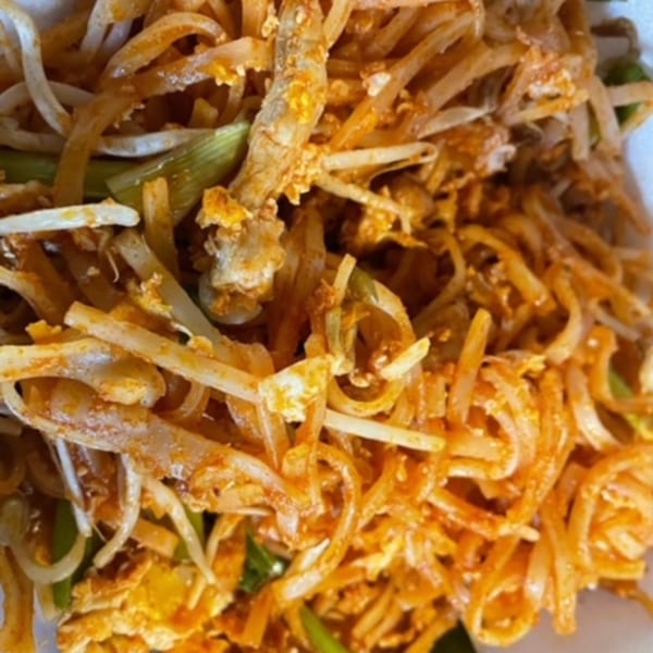 Close-up of Thai Pad See Ew noodles with bean sprouts, chicken, and green onions.